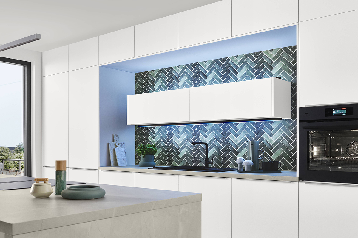 Geschmackvolle Atmosphäre! Die edle Arbeitsplatte in Nussbaumoptik setzt einen warmen Akzent zum Schiefergrau und schafft ein angenehmes Ambiente. Für die passendeLichtstimmung sorgen die Philips Hue Einbaustrahler, die smart zwischen Arbeitslicht und Wohnlichkeit wechseln.